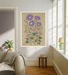September birth flower art print of purple asters and pink morning glory in a gold frame, Aster September lettering, leaning against a panelled wall