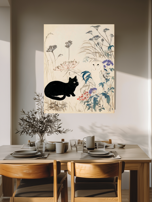Black cat and owl meadow print on a warm neutral dining room wall above an oak table set for two