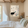 Japandi cat and barn owl print above a bedside table in a beamed bedroom with sage green pillows