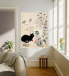 Black cat and barn owl wildflower meadow wall art in a sunlit living room above a wooden side table