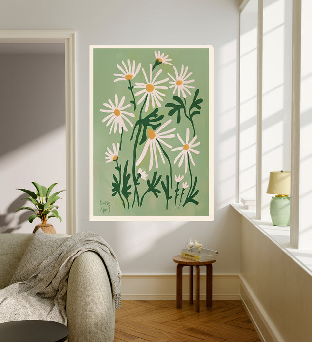 April birth flower art print of white daisies on sage green in a gold frame, Daisy April lettering, leaning against a panelled wall