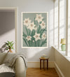 December birth flower art print of white narcissus on sage green in a gold frame, Narcissus December lettering, leaning against a panelled wall