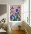 Purple violet birth month flower art print hanging in a sunlit living room above a linen armchair with side table and plant