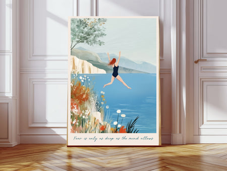 Wild swimming art print in a gold frame with the quote Fear is only as deep as the mind allows, woman jumping into a blue lake with wildflowers and mountains
