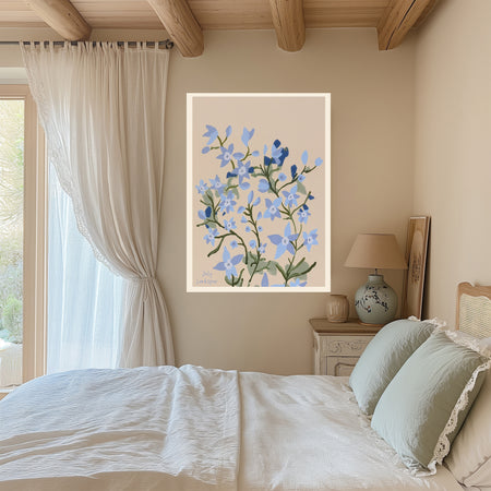 July Larkspur birth flower print hanging in a sunlit living room above a linen armchair with side table and plant
