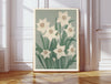 Narcissus December birth flower print hanging in a sunlit living room above a linen armchair with side table and plant