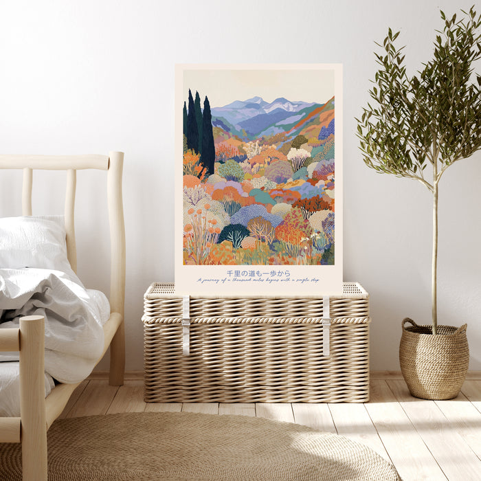 Colourful Japanese landscape art print resting on a wicker chest beside a bed and olive tree in a neutral bedroom