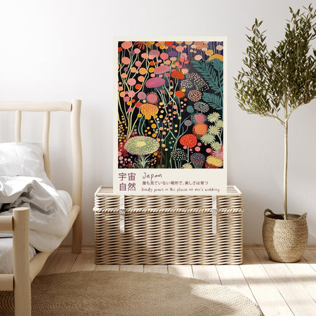 Dark floral Japanese quote art print resting on a wicker chest beside a bed and olive tree in a neutral bedroom