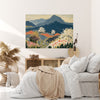 Navy and terracotta mountain wildflower canvas above a cane sideboard in a sunlit neutral bedroom with pampas grass