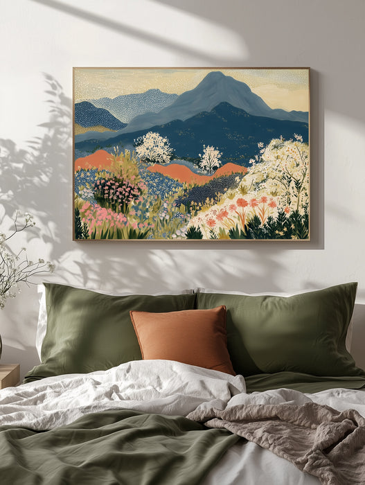 Mountain wildflower meadow print in a pale oak frame above a bed with olive green bedding and terracotta cushion