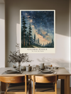 Starry night sky over tall pines, painterly celestial print in a cosy bedroom