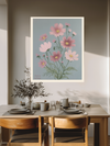 Pink cosmos birth month flower print above a wooden dining table with olive branches and stoneware