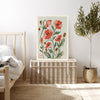 August poppy birth flower print resting on a wicker chest beside a bed and olive tree in a neutral bedroom