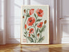 August birth flower art print of red and pink poppies in a gold frame, Poppy August lettering, leaning against a panelled wall