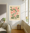 June birth flower art print of pink roses on cream in a gold frame, The Rose June lettering, leaning against a panelled wall