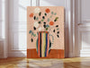 Striped vase flower art print with cream and coral roses in a rainbow striped jug, leaning against a panelled wall on herringbone floor