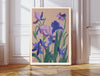 February birth flower art print of purple violets and irises in a gold frame, Violet February lettering, leaning against a panelled wall